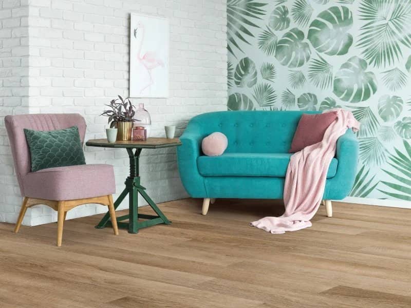 blue couch in living space with leaf wall paper | Mitchell's Flooring & Design | Serving Northern Colorado | 70-352-7251 |