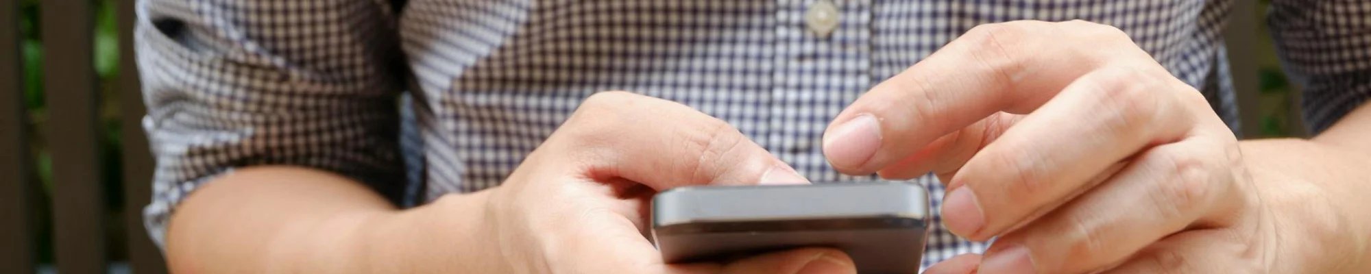 man dialing a number on a cell phone | Mitchell's Flooring & Design | Serving Northern Colorado | 970-352-7251 |